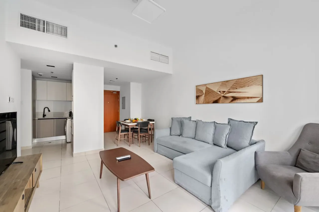 A bright living room with seating, a coffee table, and a dining area.