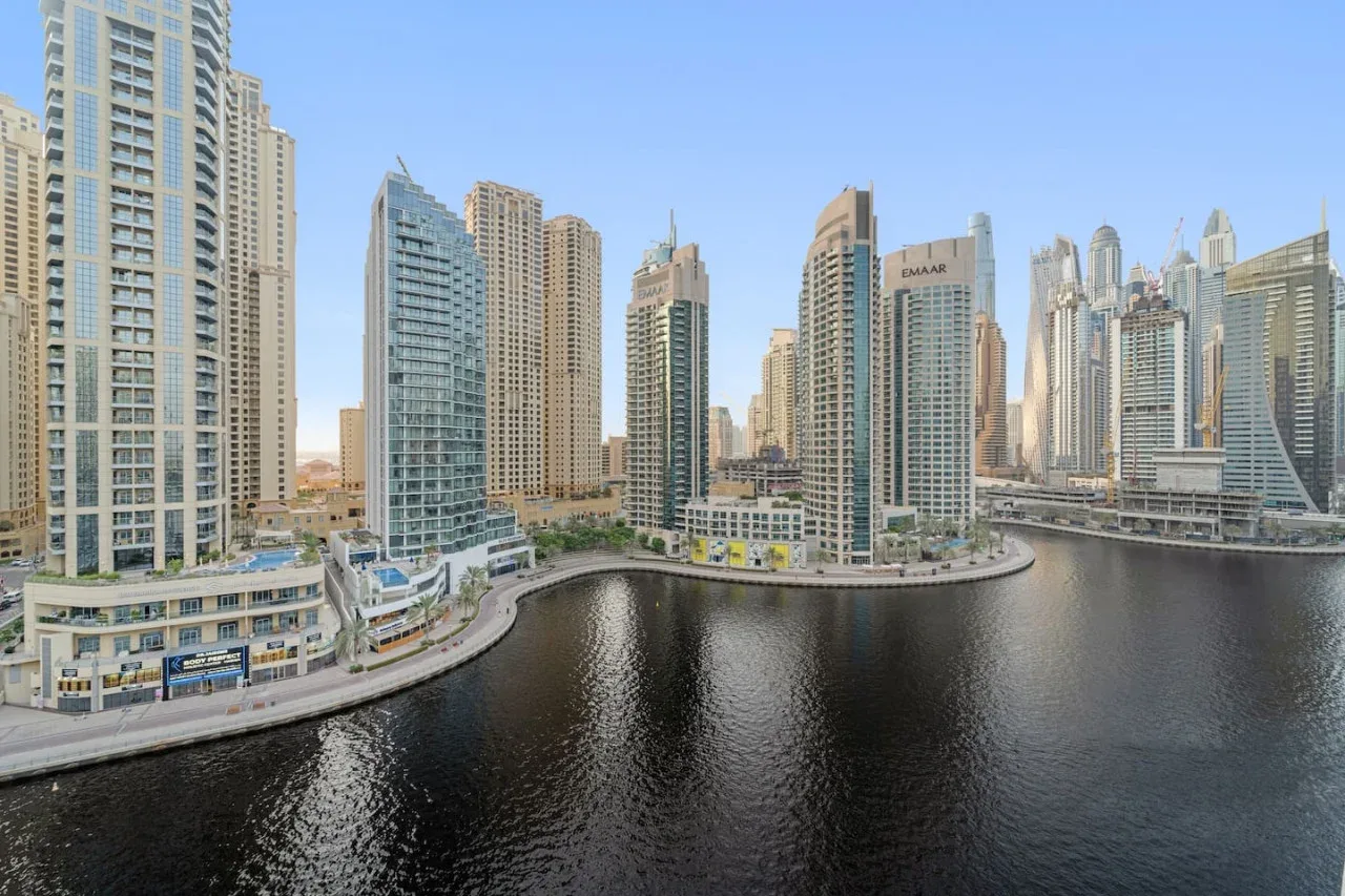A waterfront cityscape of high-rise buildings lining a curved canal.