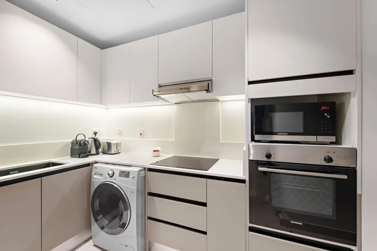 A modern kitchen with built-in appliances and a washing machine.