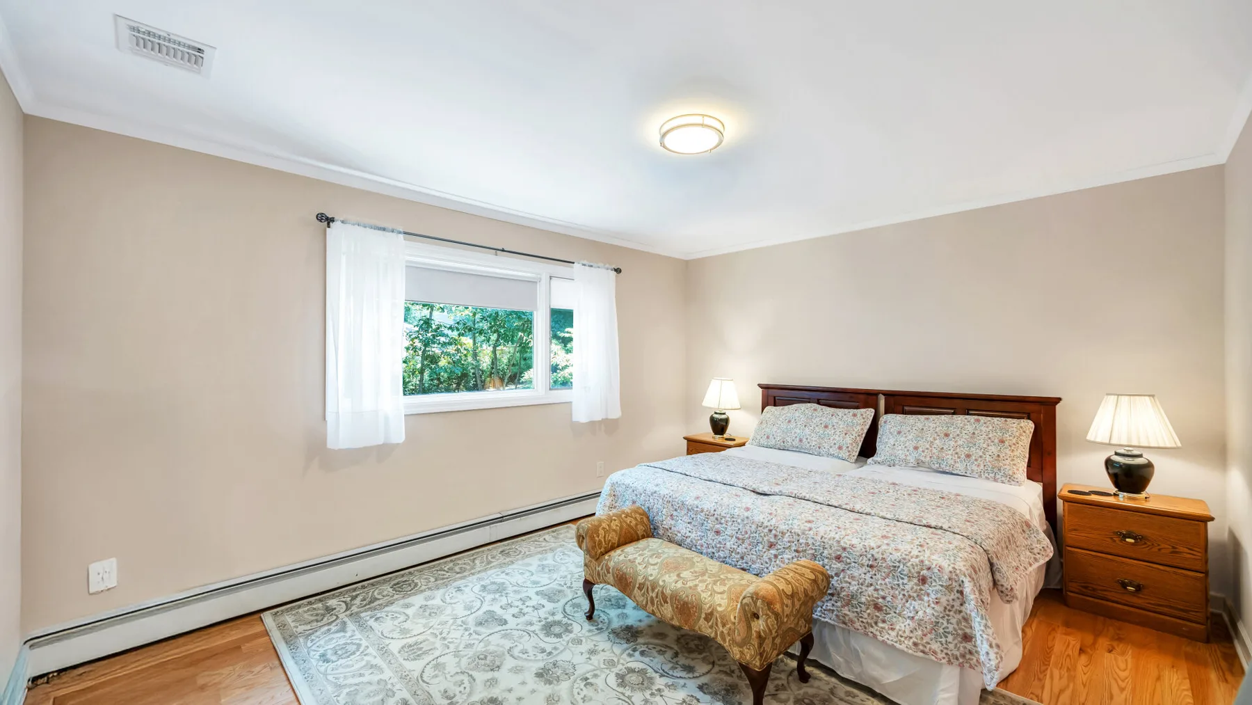 Un dormitorio con una cama, una mesita de noche y una ventana.