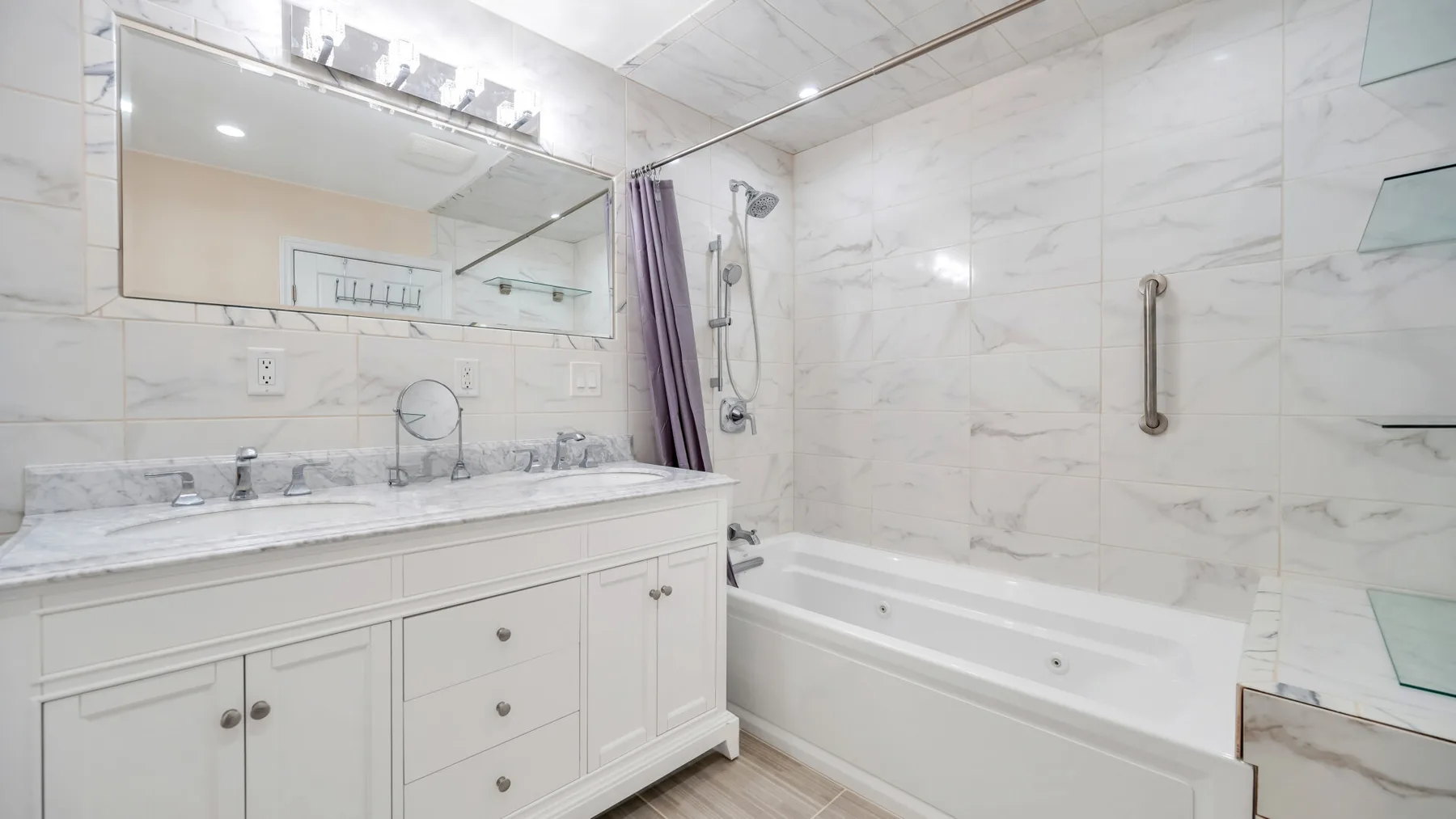 Un baño luminoso con un tocador largo junto a una bañera.
