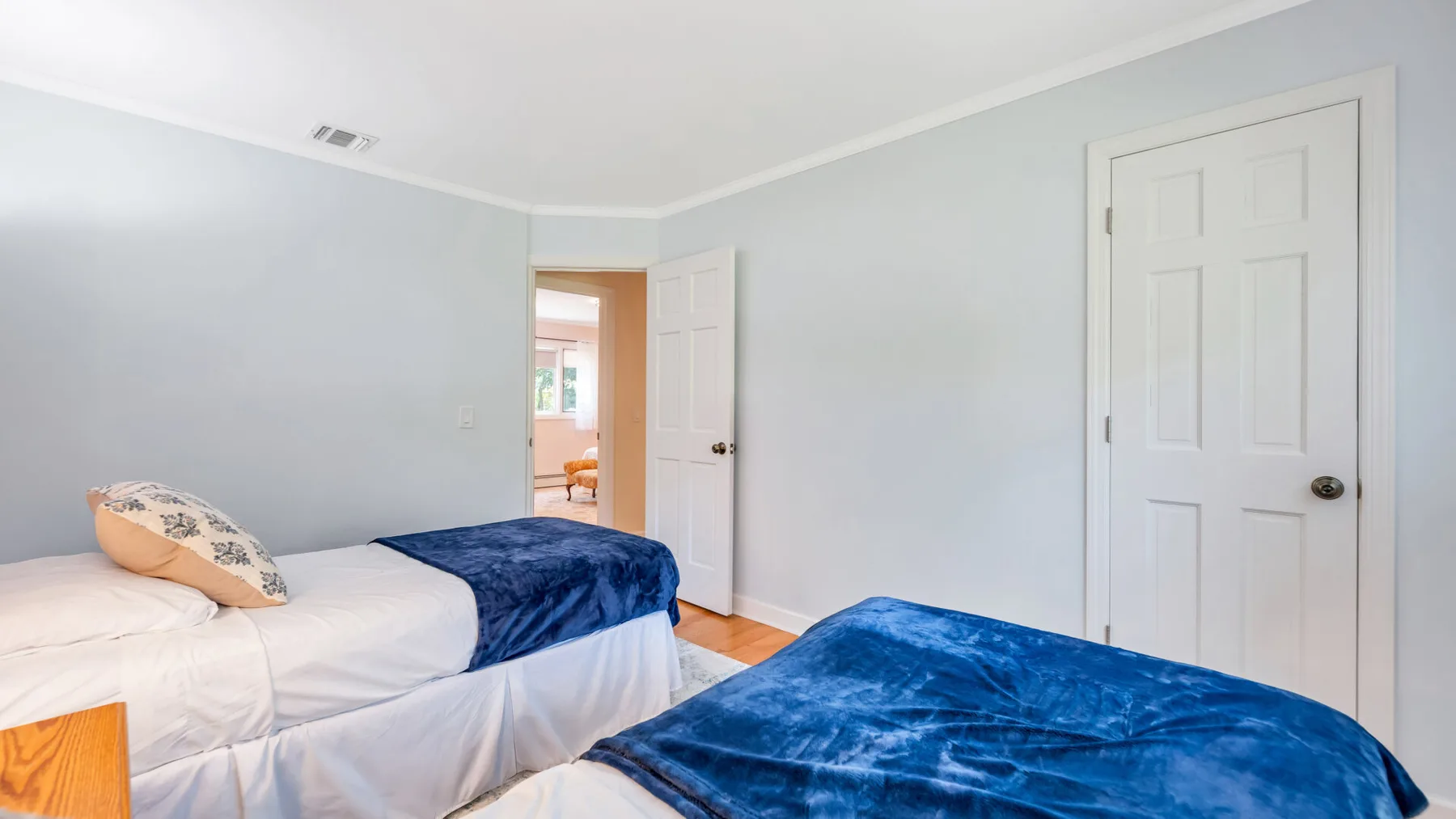Un dormitorio con dos camas, ambas cubiertas con ropa de cama azul.
