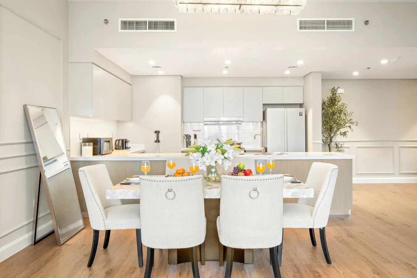 Un comedor luminoso con una mesa puesta frente a una cocina moderna.