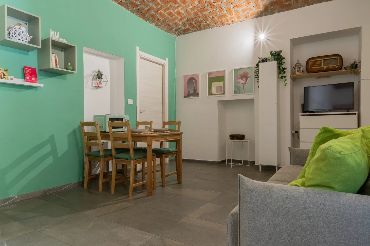 A living and dining area with a table, seating, and a television.