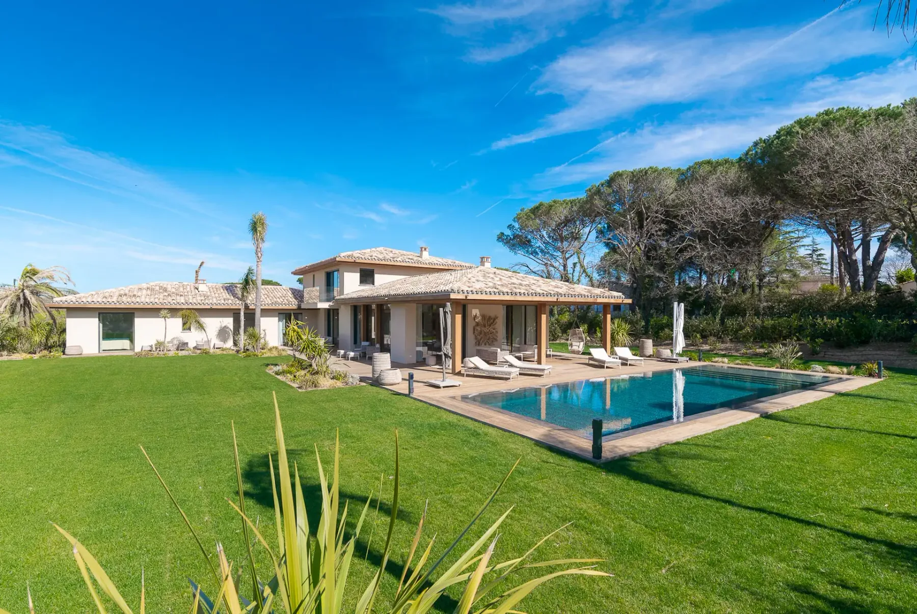 Extenso jardín con césped, piscina y terraza