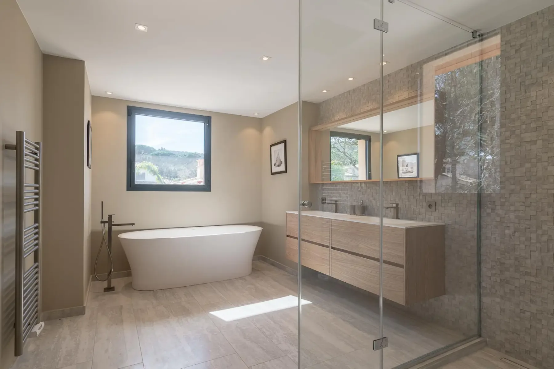 Baño grande y moderno con ducha de cristal, bañera y lavabo doble con espejo