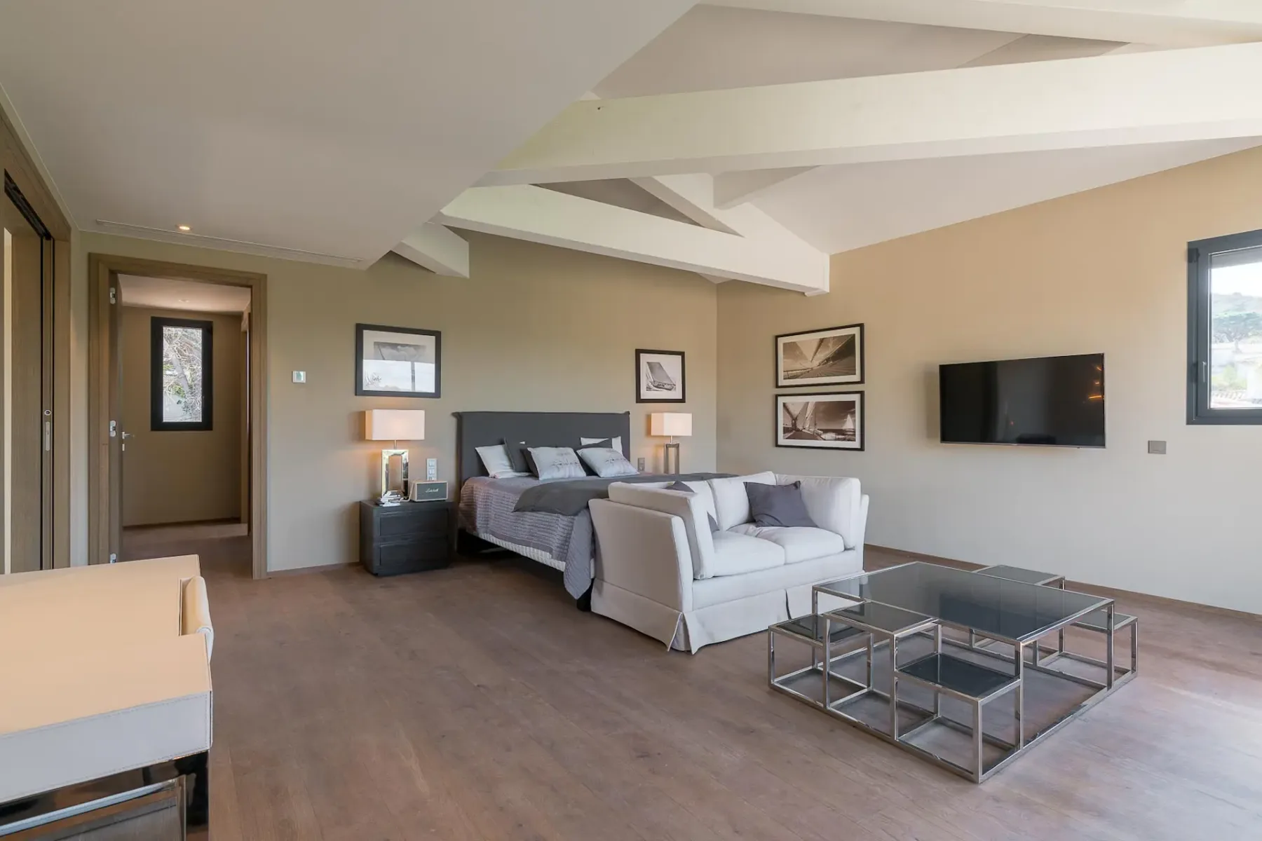 Un dormitorio con cama, zona de estar y televisor.