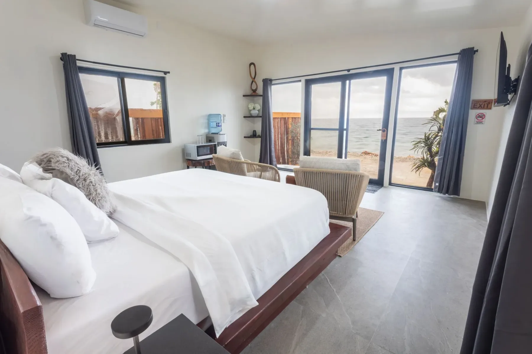 Bedroom and sitting area with ocean-view windows and a balcony.