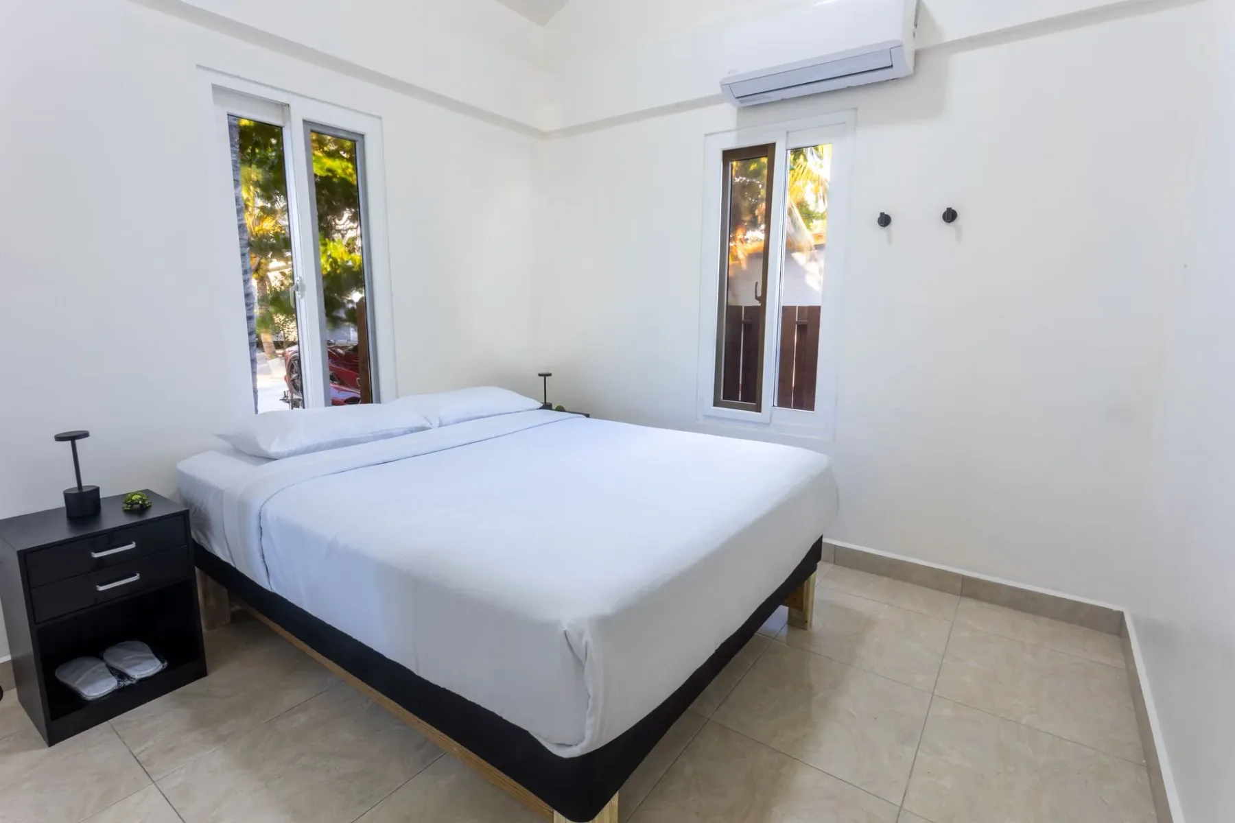 Bedroom with a white bed and wall-mounted air conditioner.
