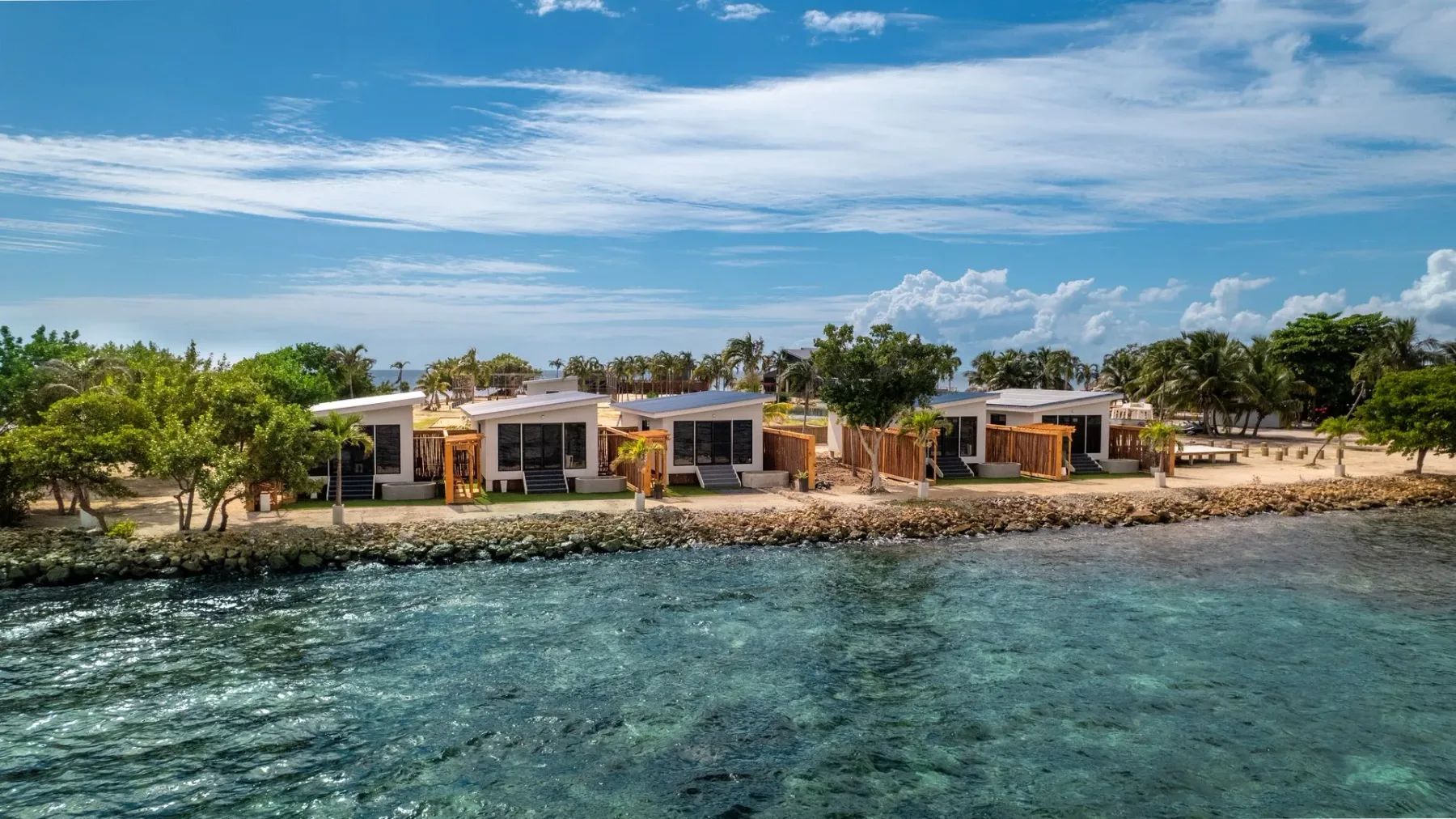 Seaside resort villas beside turquoise water.
