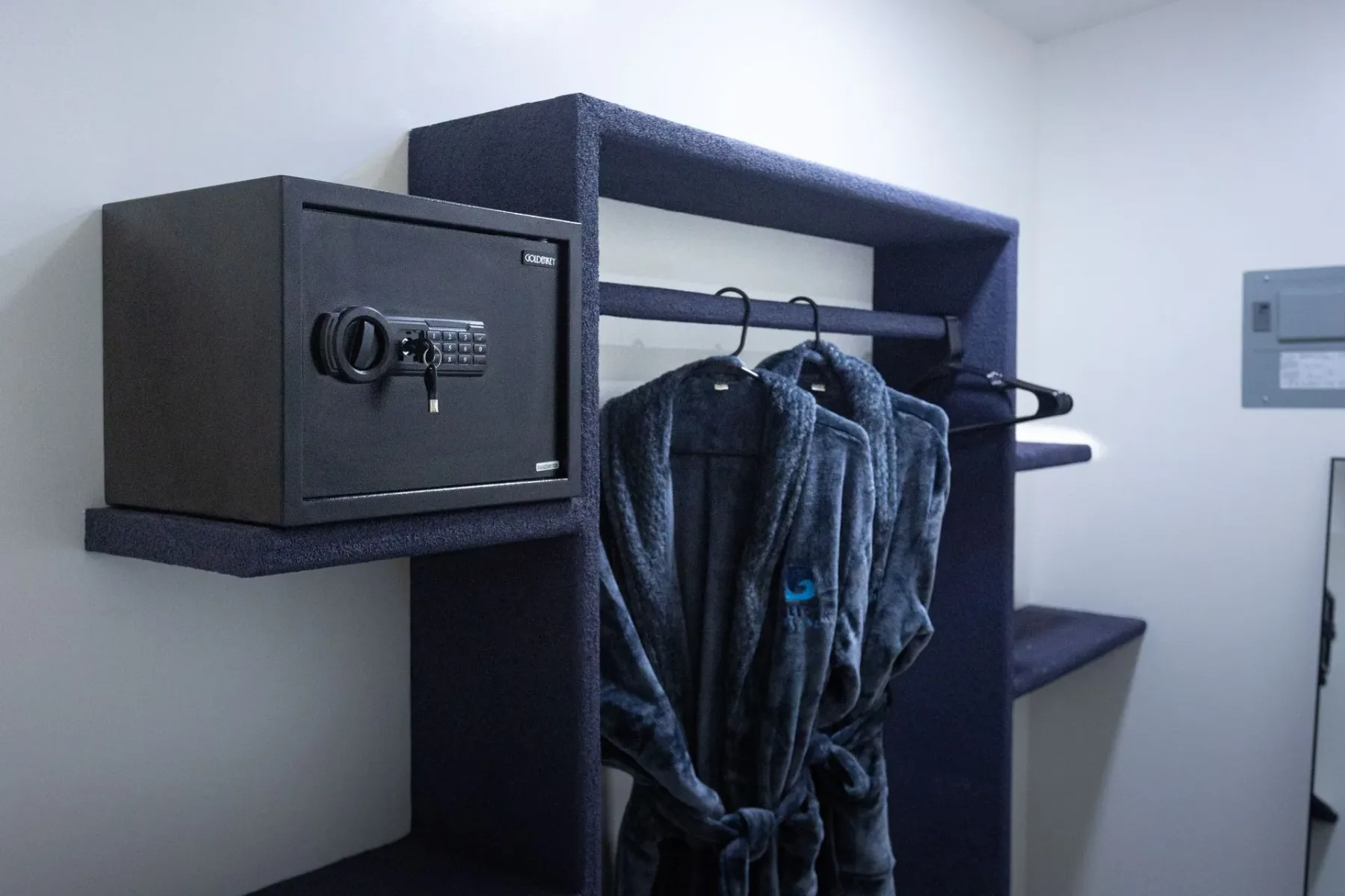 In-room safe beside hanging clothes.