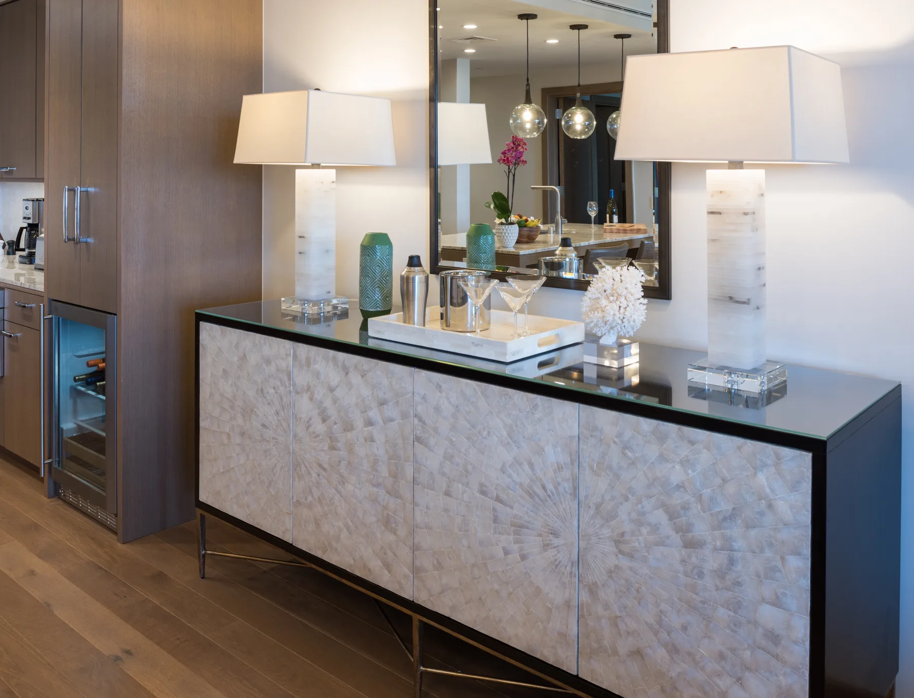 Un interior moderno con un aparador largo, objetos decorativos y lámparas de mesa.