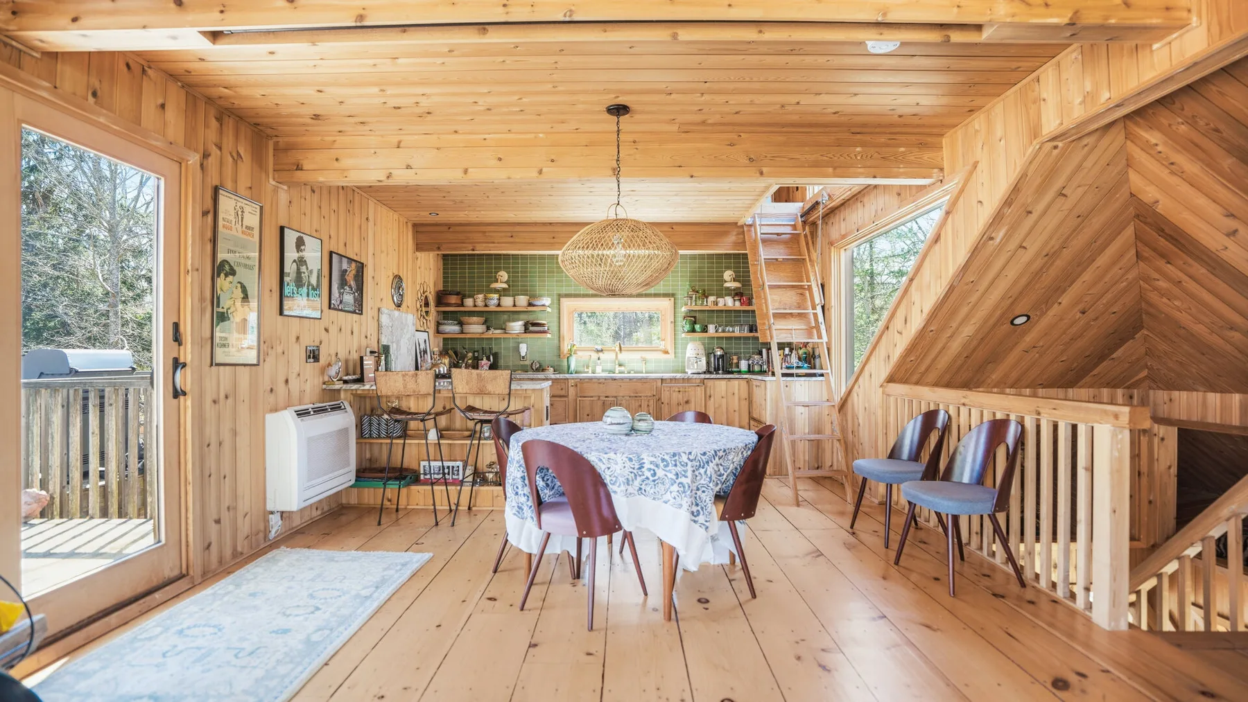 Un comedor revestido de madera con una mesa, sillas y estantes empotrados.