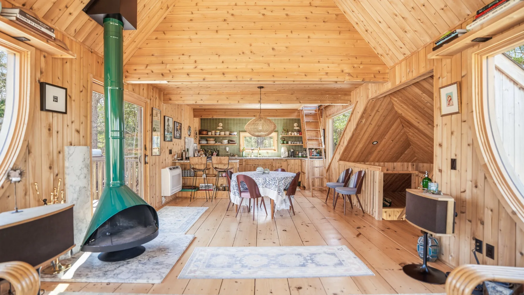 Una habitación revestida de madera con una mesa de comedor y una chimenea independiente.