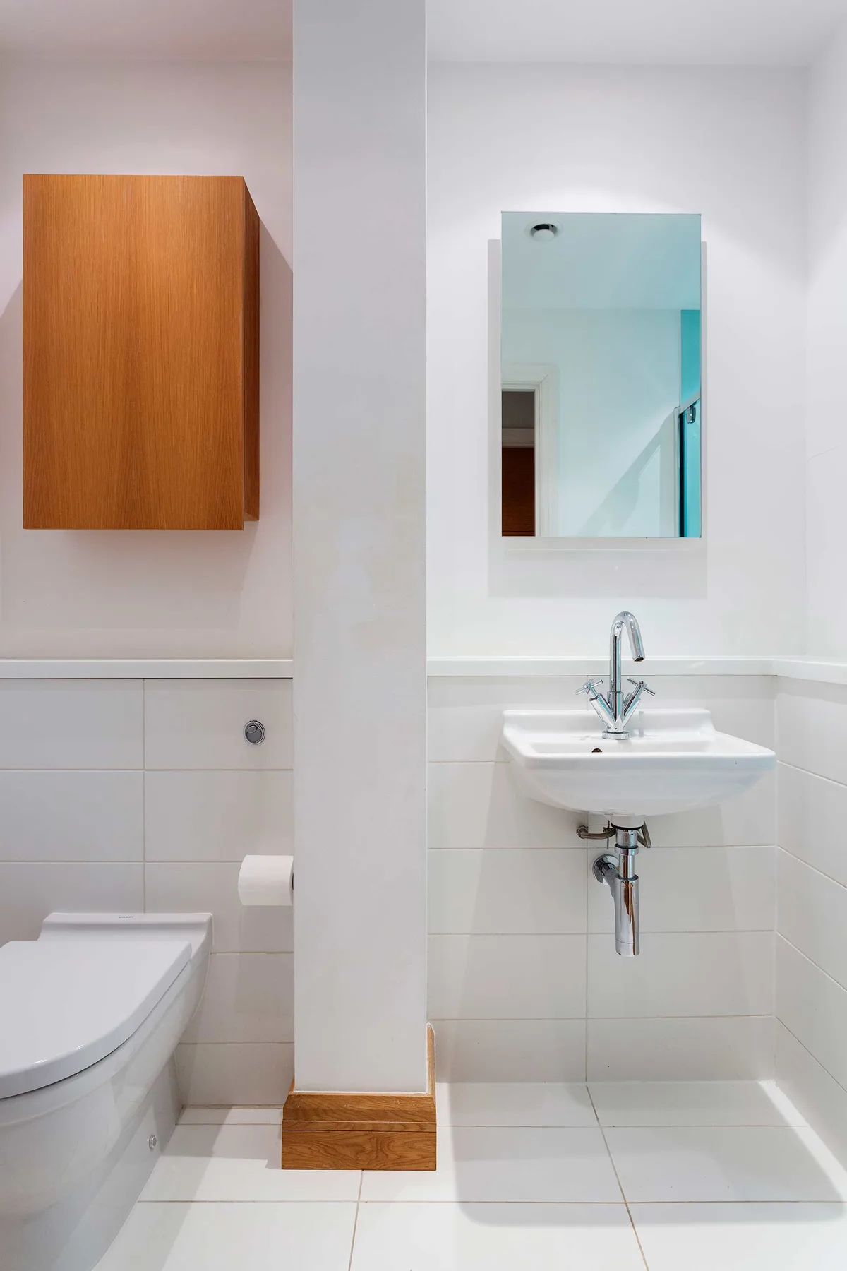 A tiled bathroom with a sink, mirror, and toilet.