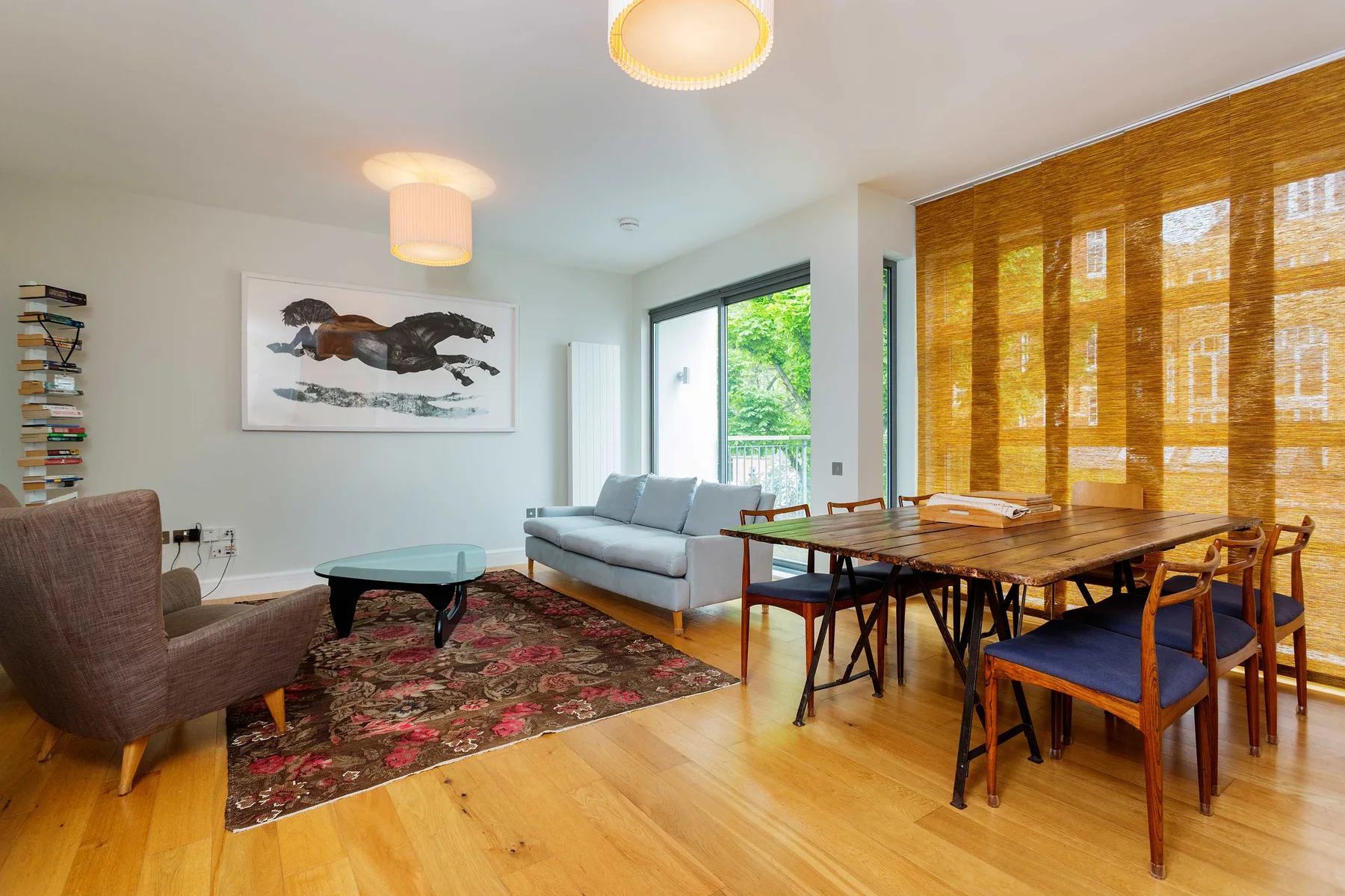 A living and dining room with a seating area beside a wooden dining table.