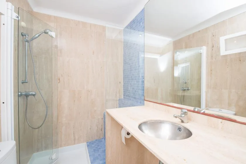 Un baño con una ducha de vidrio y un lavabo integrado en una encimera.