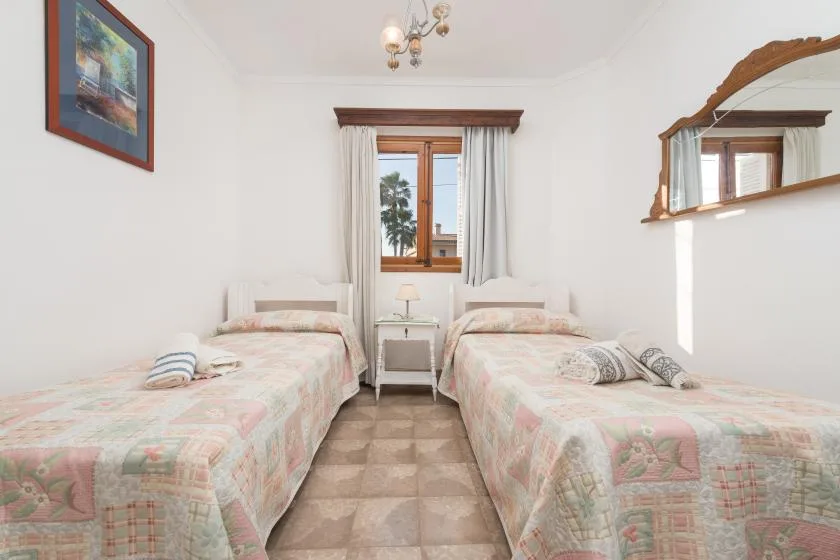 Un dormitorio con dos camas individuales y una ventana entre ellas.
