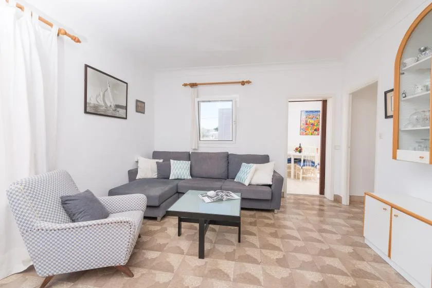 Una sala de estar con asientos alrededor de una mesa de centro y una ventana.