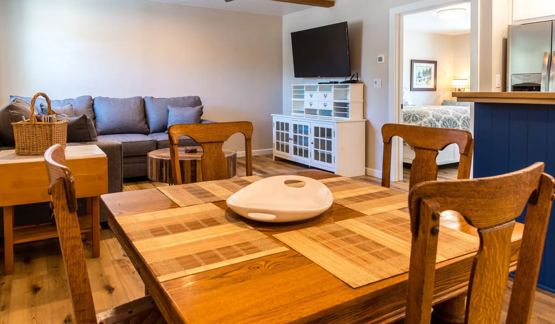 Una sala de estar y comedor con un sofá y una mesa de madera.