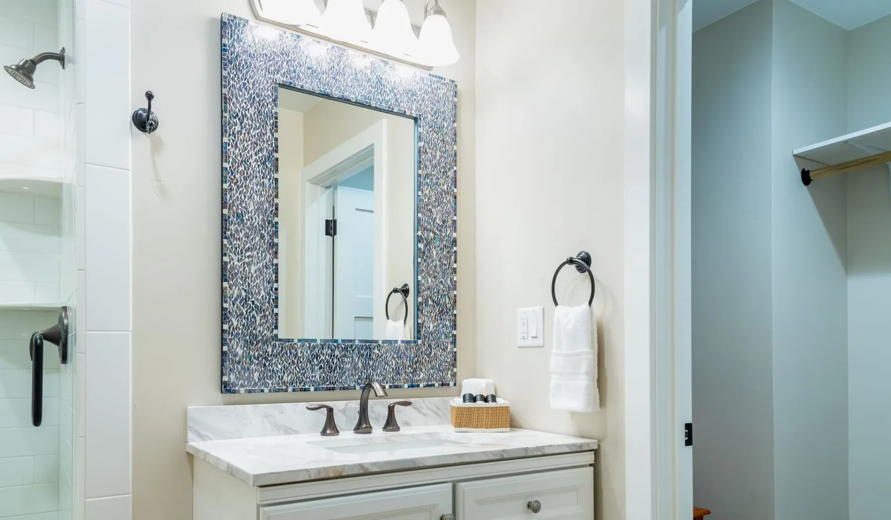 Un lavabo de baño con un espejo grande enmarcado y una ducha cerca.