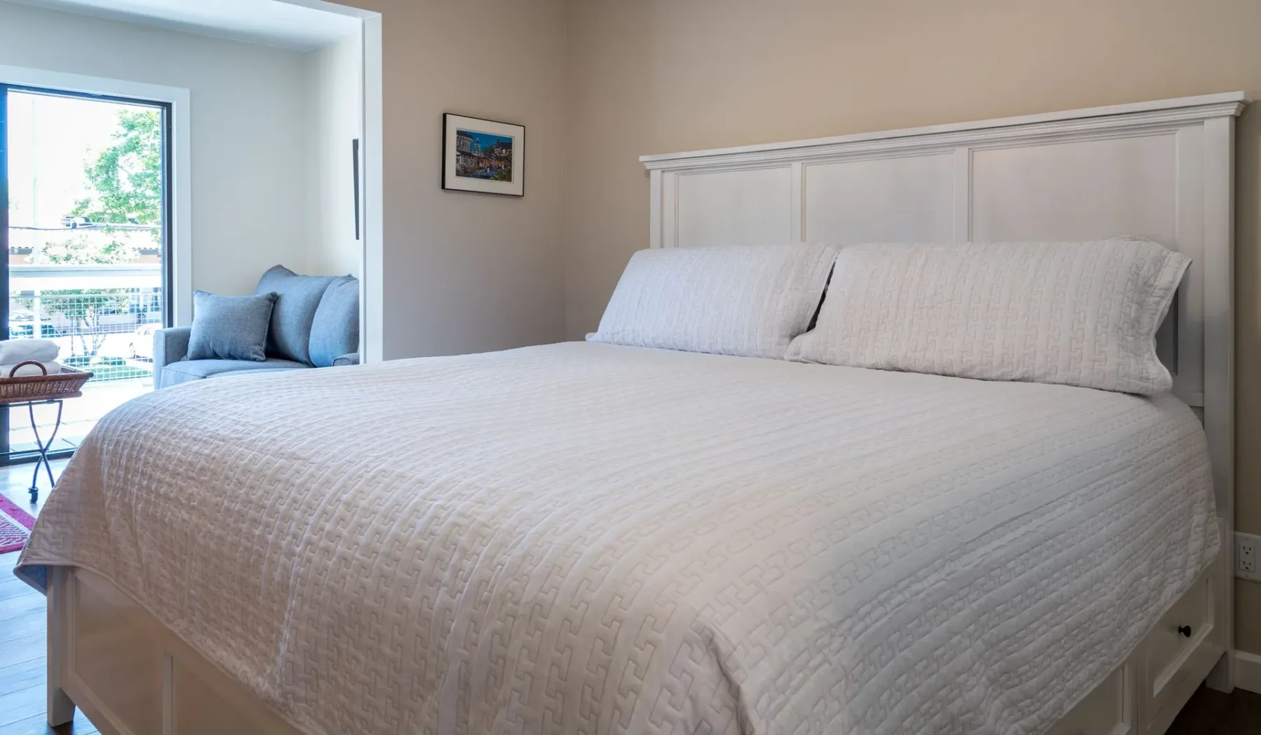 Un dormitorio con una cama grande y una ventana que da a un balcón.