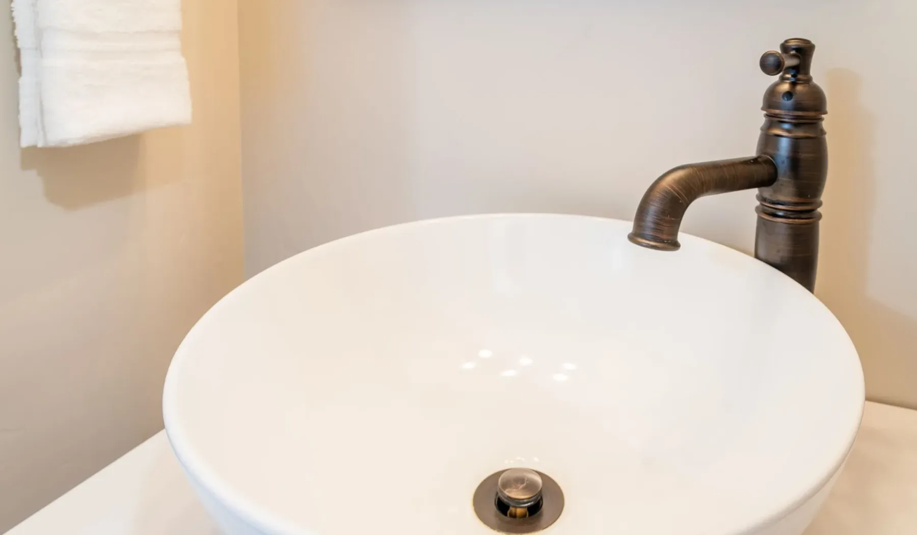 Un lavabo blanco con un grifo de metal oscuro.
