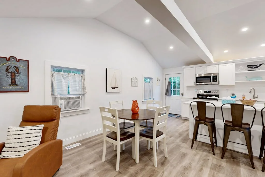 An open-plan living and dining area with a table beside the kitchen.
