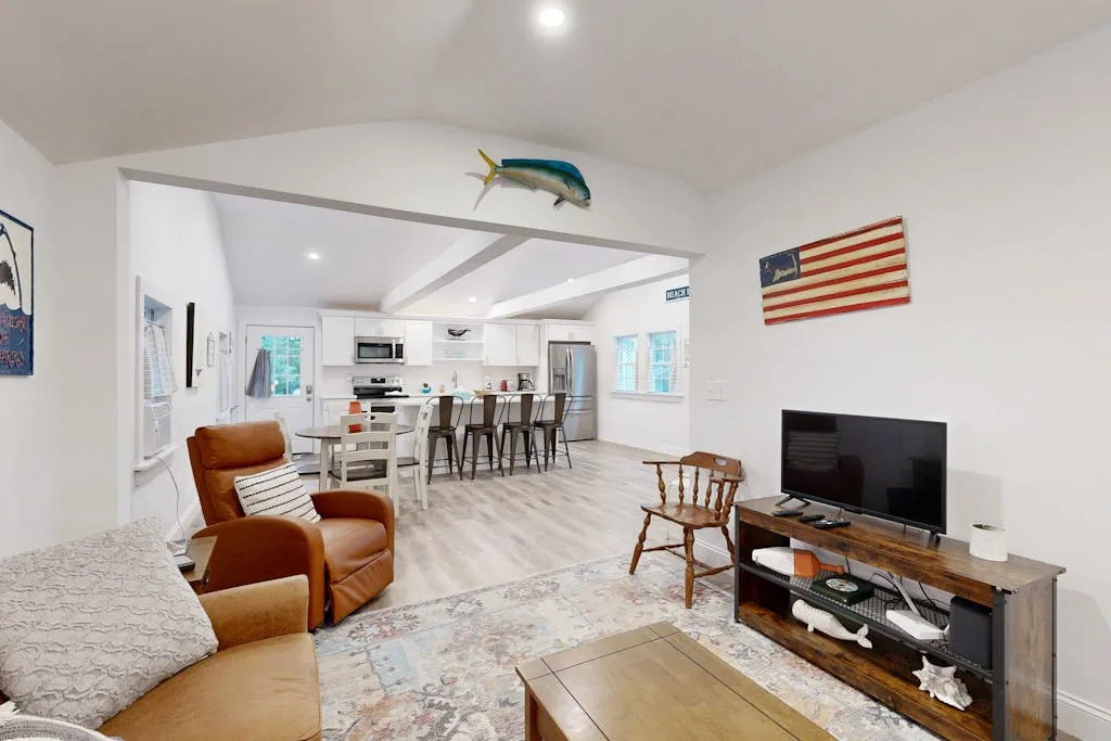 A bright living room opens onto a kitchen and dining area.