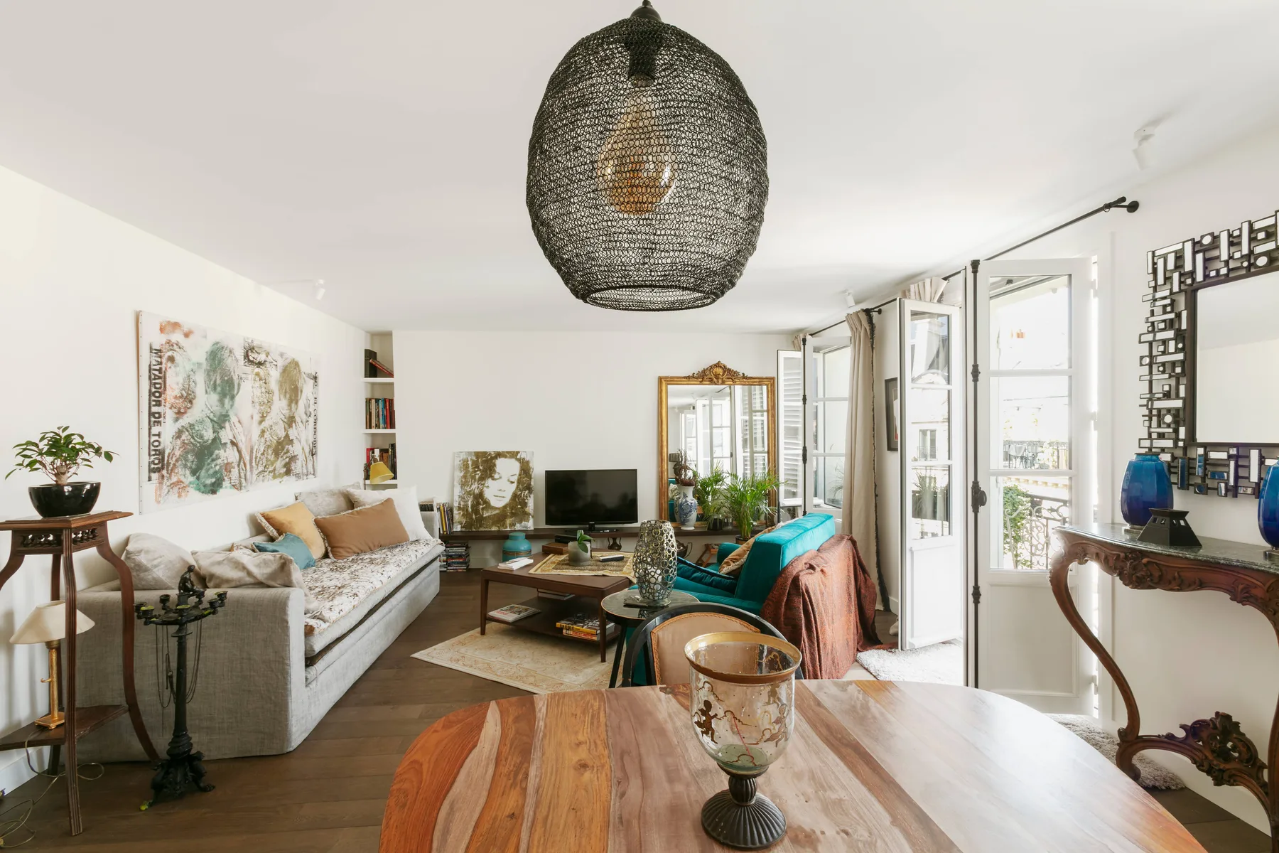 A bright living room with seating, a television, and large windows.