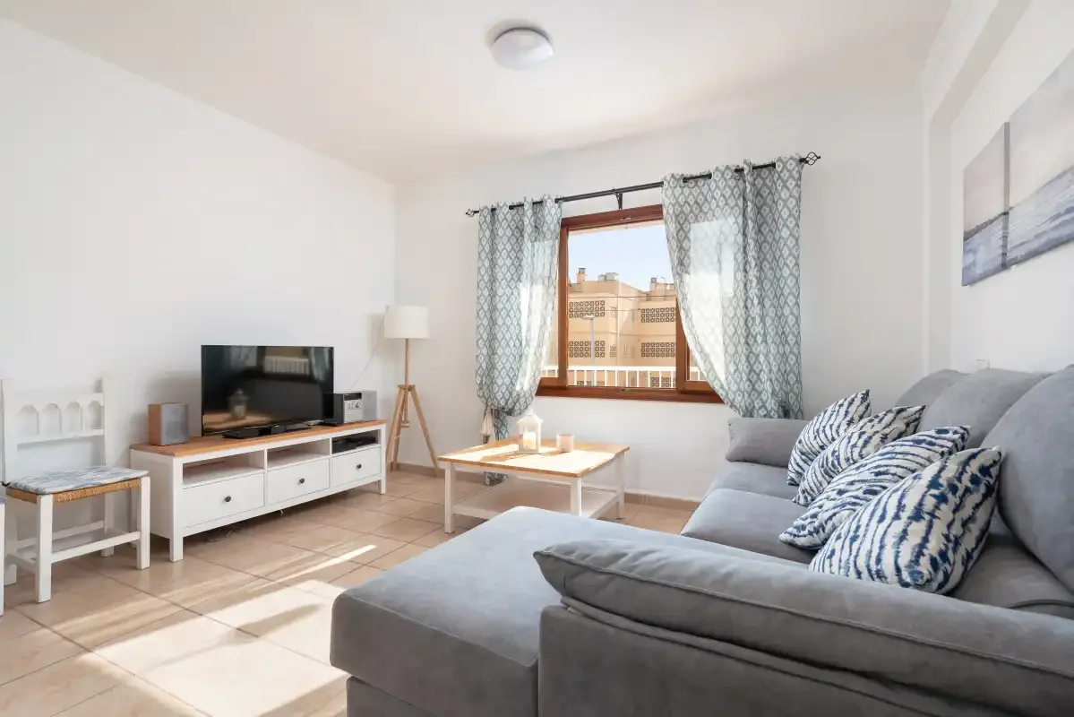 A bright living room with a gray sectional sofa and television.