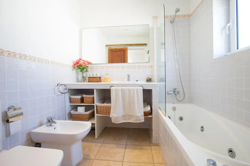 A bright bathroom with a bathtub, shower, sink, and vanity.