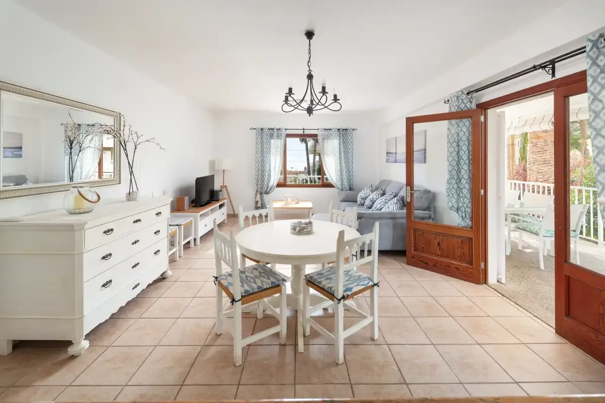 A bright dining and living room with a round table and seating.