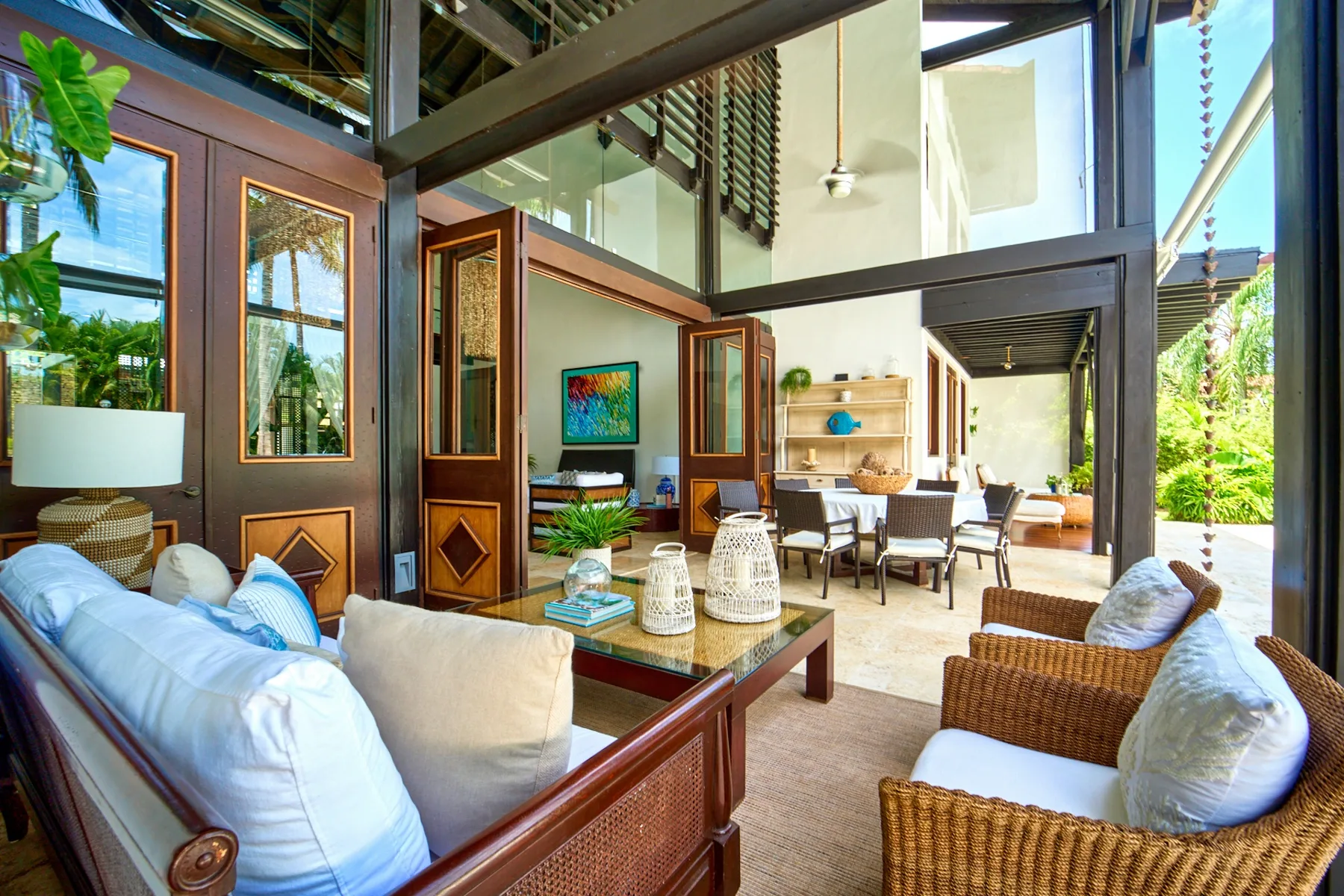 An open-plan living and dining area with seating, a table, and large windows.