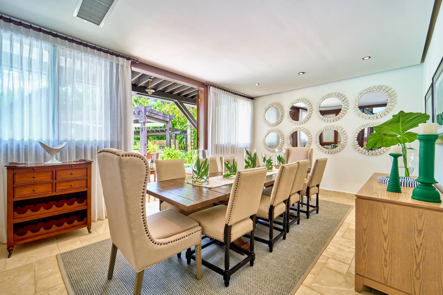 A bright dining area with a long table and upholstered seating.