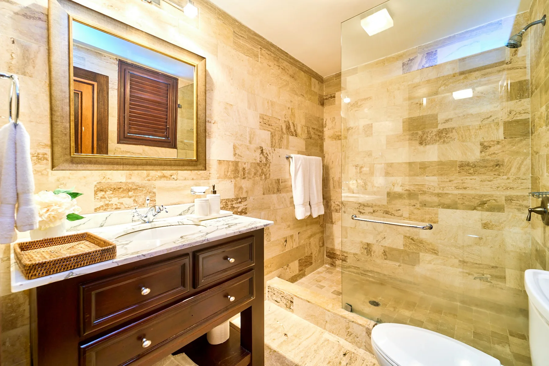 A bathroom with a dark vanity and a glass-enclosed shower.