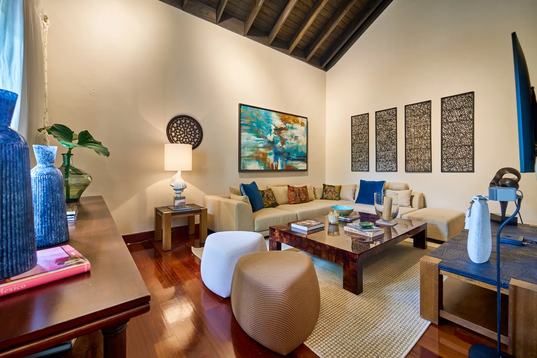 A living room with a seating area, coffee table, and colorful wall art.