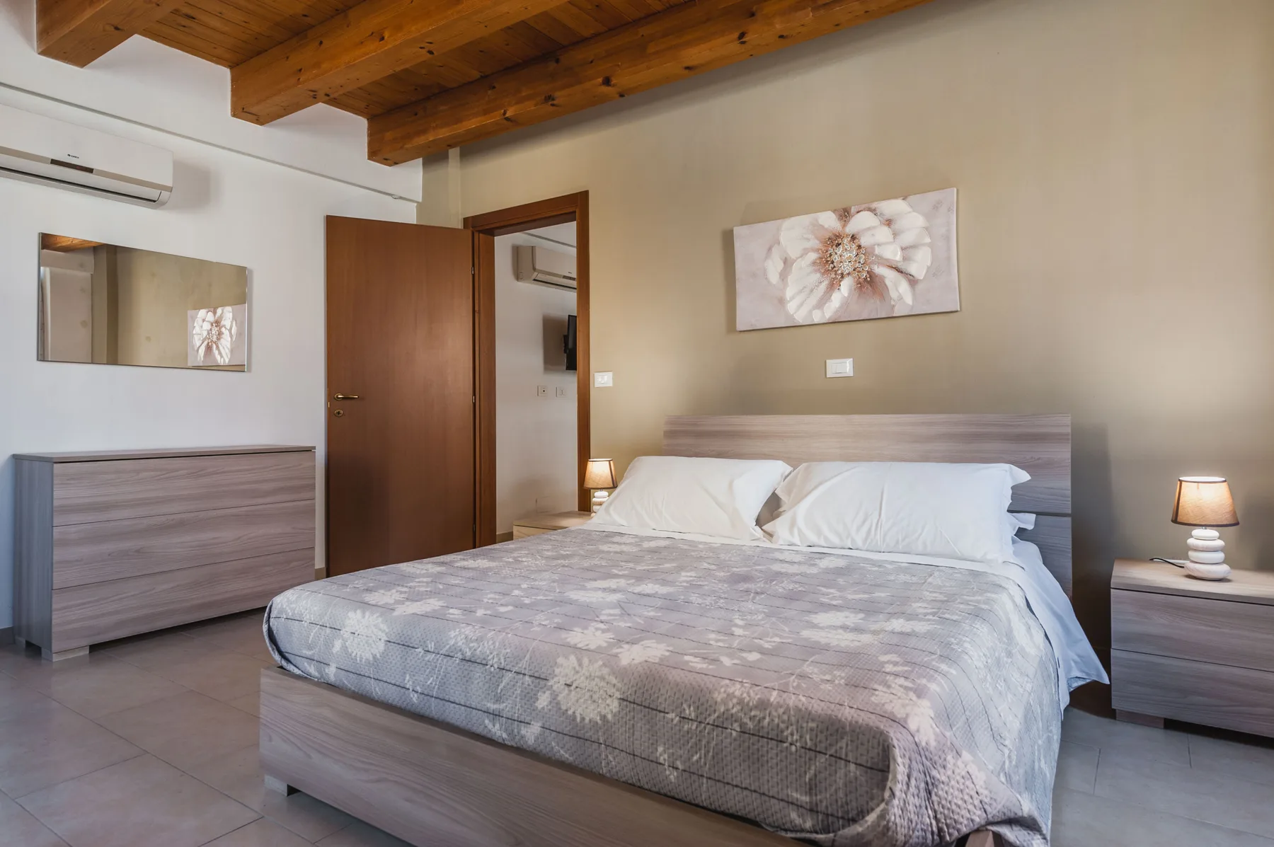 Un dormitorio con una cama, mesillas a juego y un techo de madera.