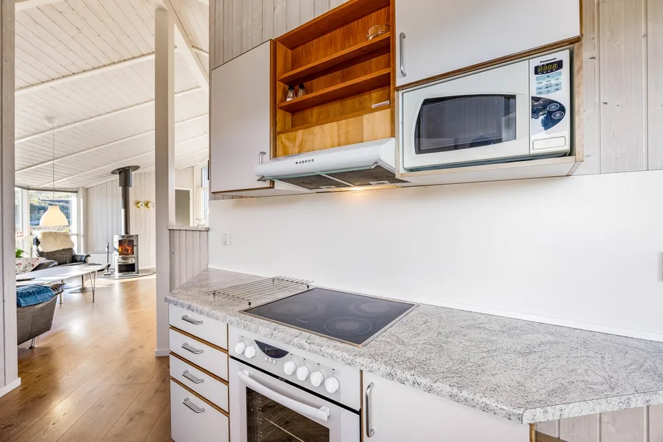 Una cocina luminosa con un microondas integrado sobre la encimera.