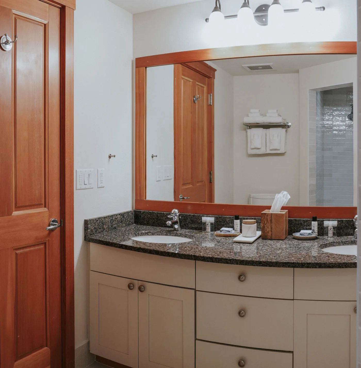 A bathroom vanity with a wide mirror and countertop sink.