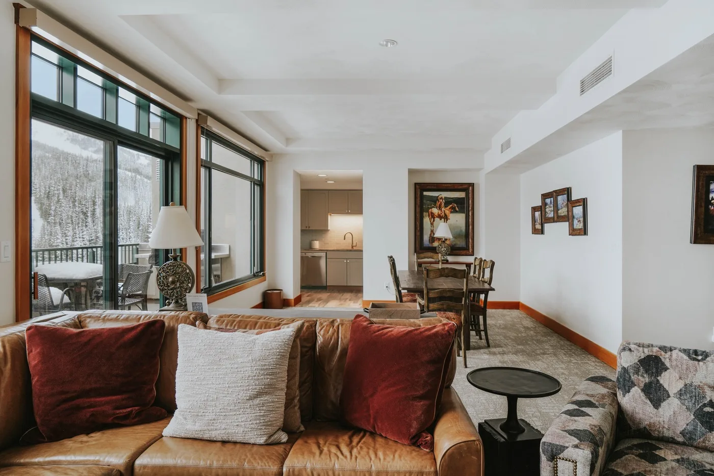 A bright living and dining area with large windows and a seating area.
