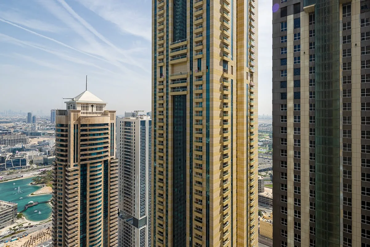 City skyline viewed between tall towers, with a marina visible below.