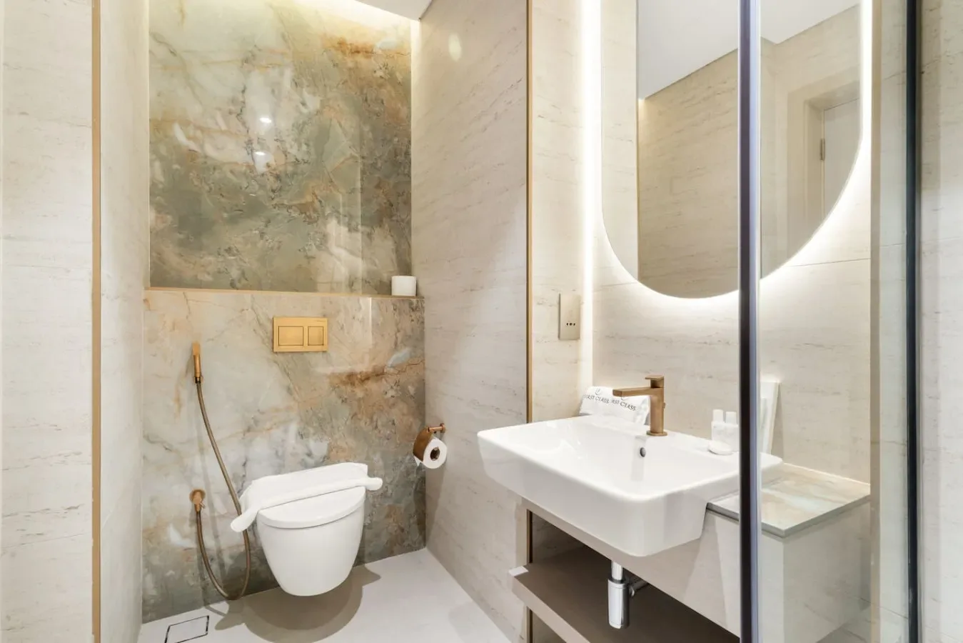 A modern bathroom with a wall-mounted sink and glass shower enclosure.