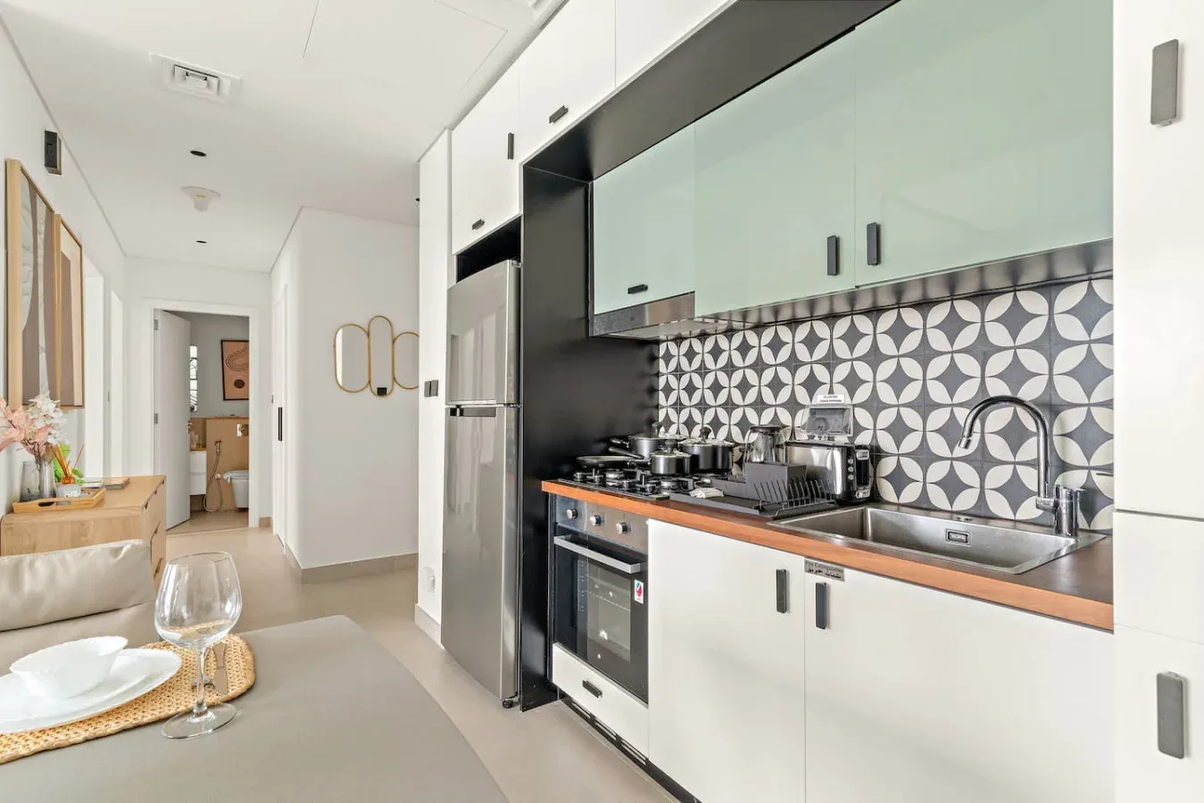 A bright kitchen with a patterned backsplash and a dining table in the foreground.