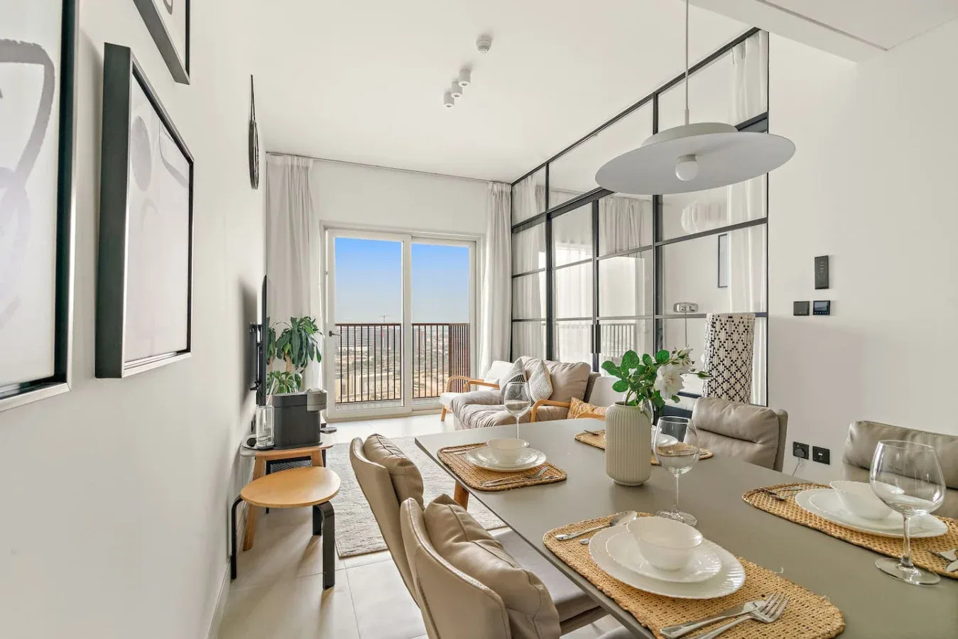 A bright dining and living area with a large table and seating beside glass doors.