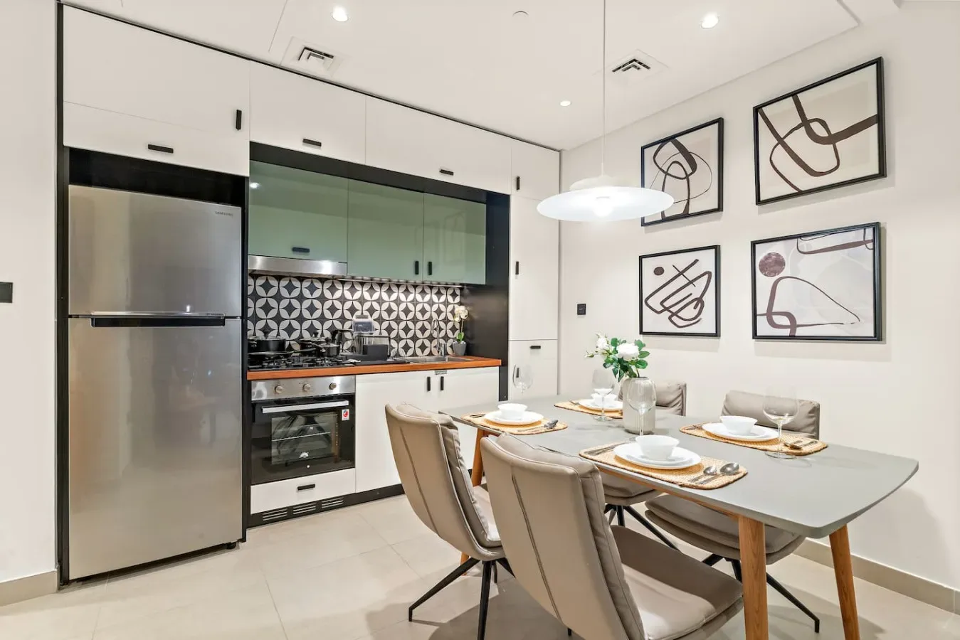 Comedor con la mesa puesta junto a una cocina moderna.