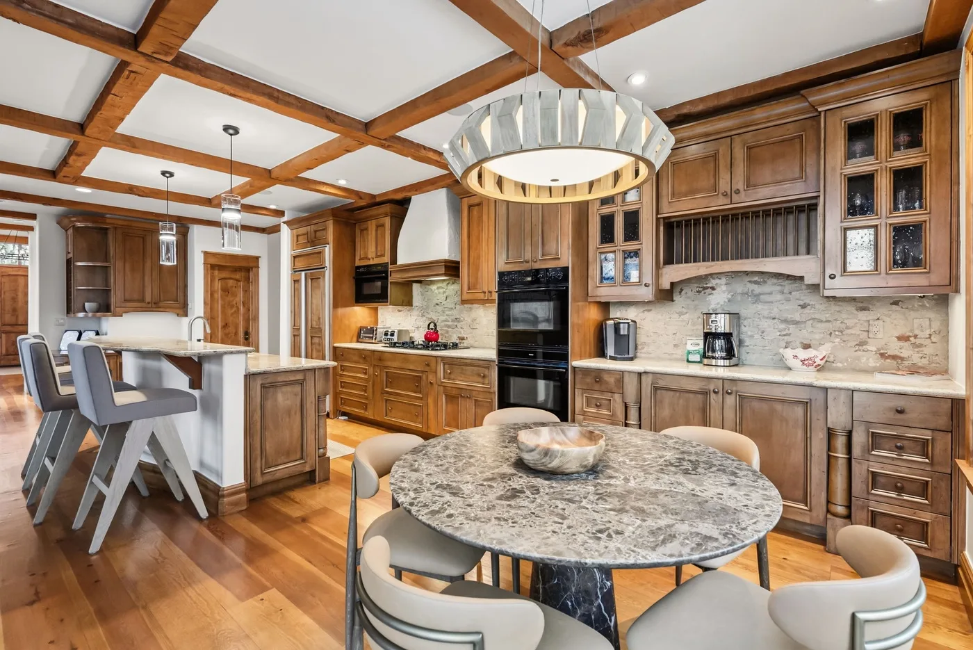 A spacious kitchen and dining area with wood cabinetry and a round table.