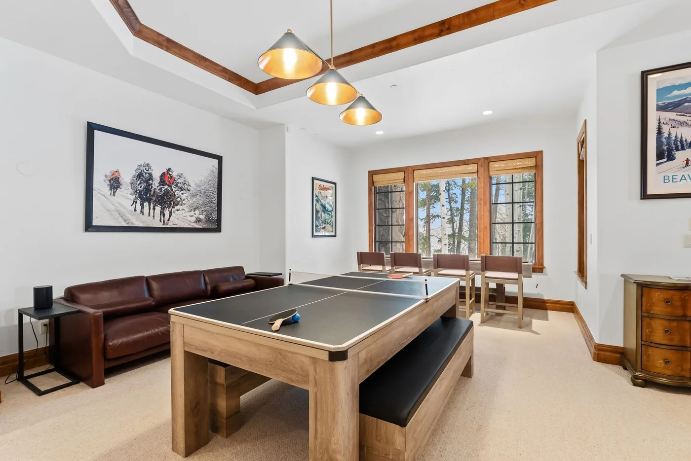 A game room with a pool table, seating, and large windows.