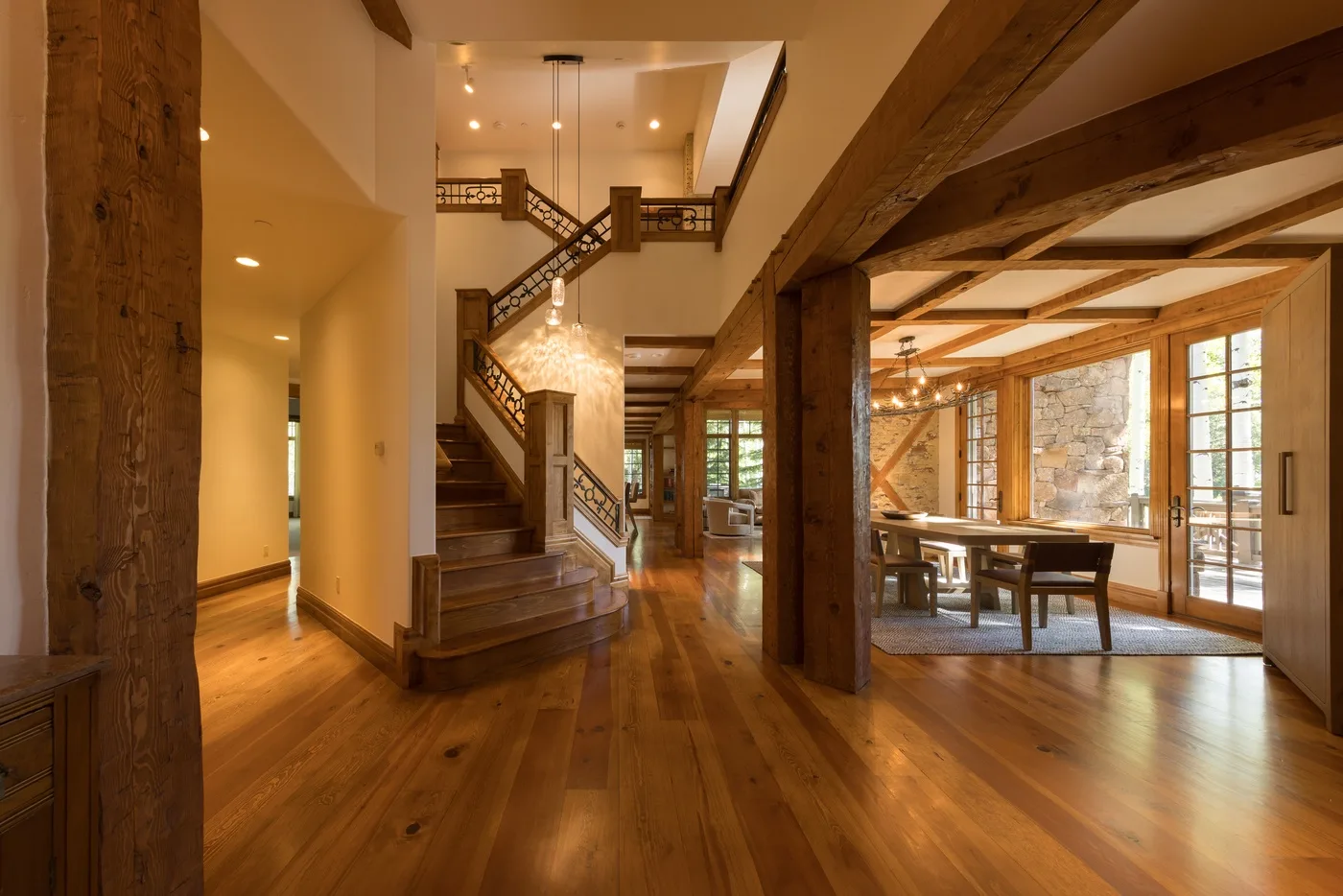 A timber-framed interior with a wooden staircase and dining table.