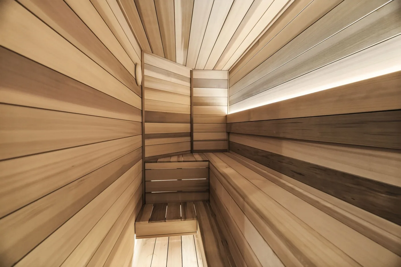 A wood-paneled sauna with tiered bench seating.
